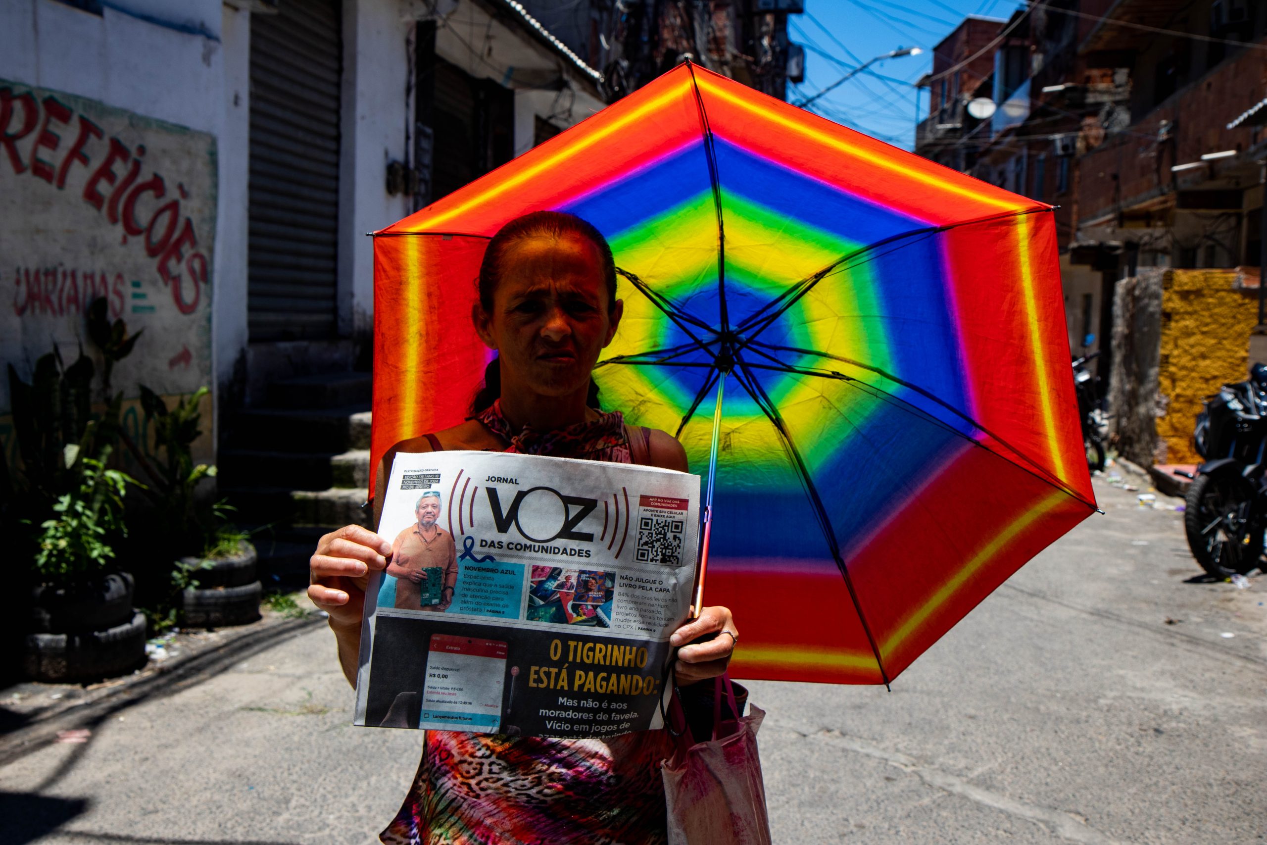 Dona Maria que mora nas casinhas em um dia de sol de verão estava com seu guarda sol colorido com as cores do arco-íris. Foto: Vilma Ribeiro